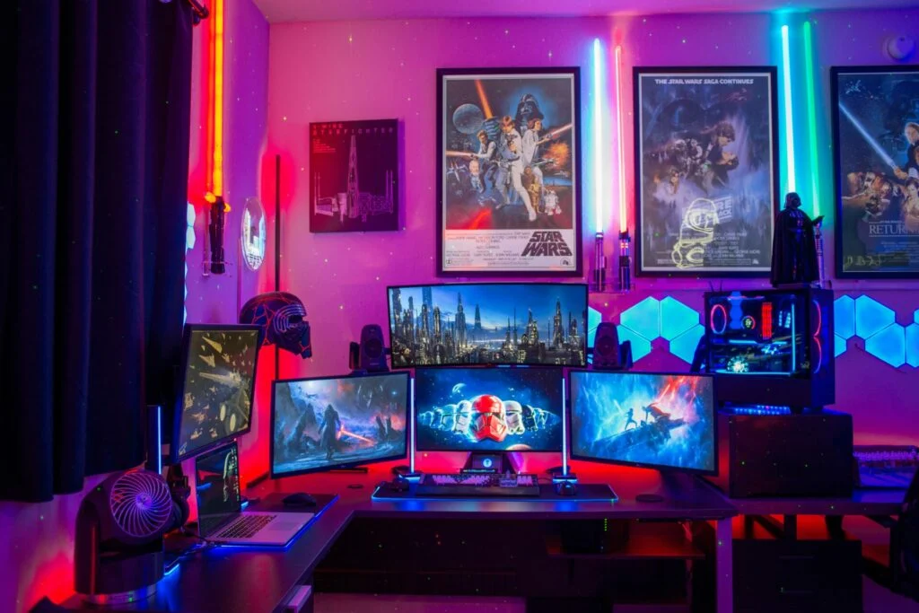 Colorful gaming room with multiple screens and LED lights.