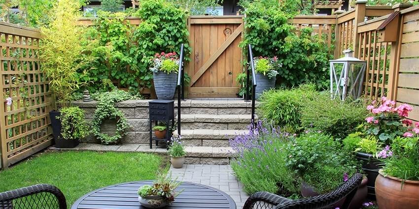 Cozy backyard garden with lush plants and patio seating.