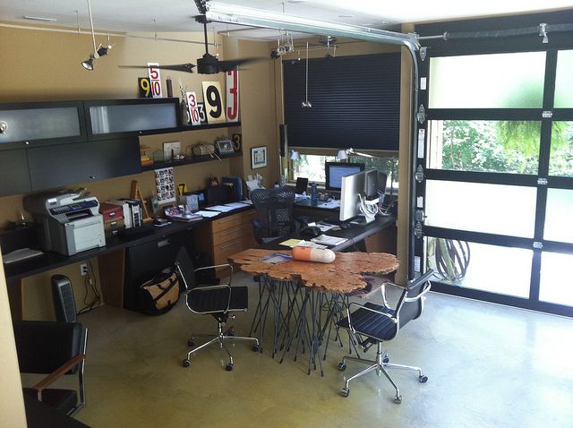 Modern home office with garage door and eclectic decor.