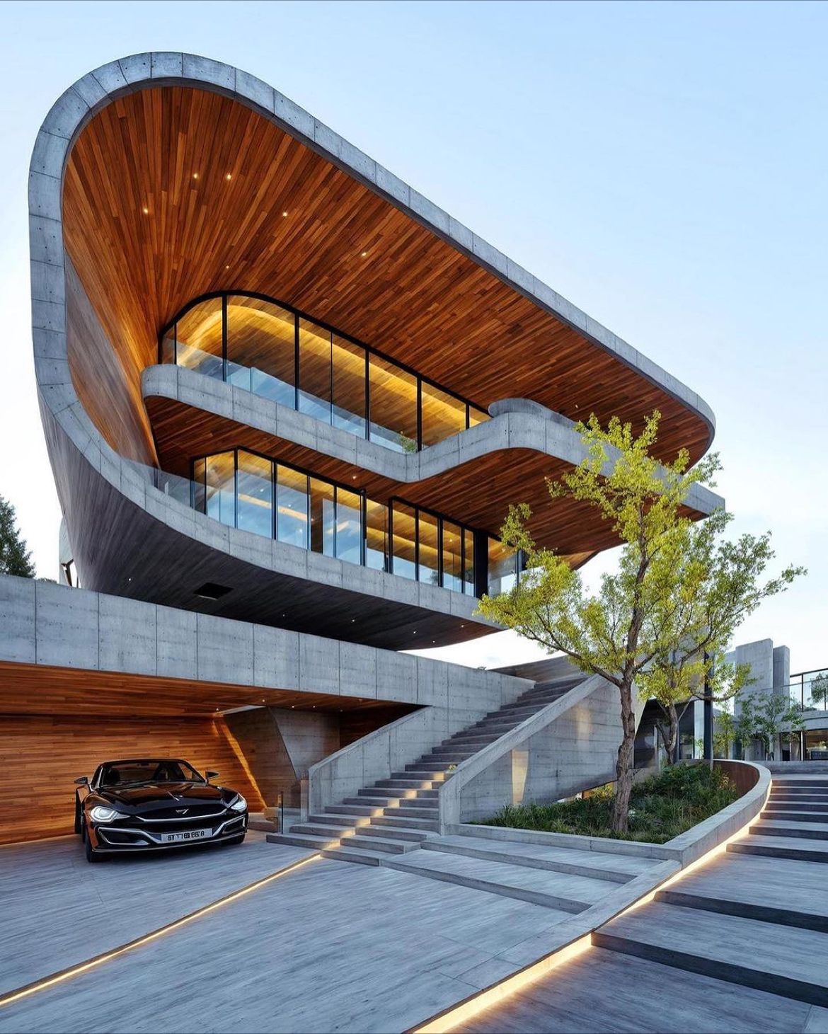 Modern architecture building with luxury car at entrance.