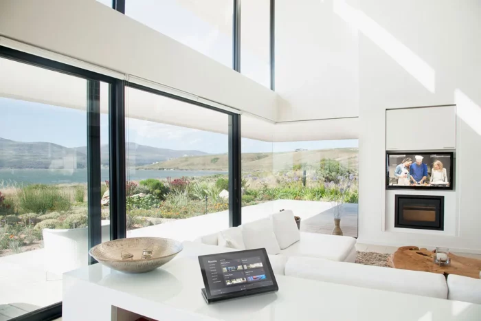 Modern living room with expansive view and smart home tablet.