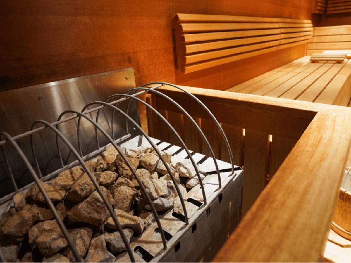 Wooden sauna interior with heated rocks.