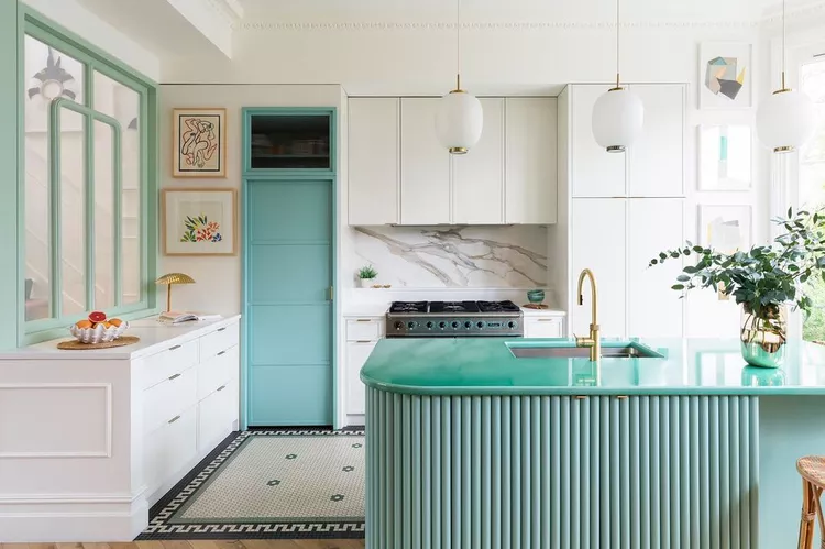 Bright kitchen interior with white cabinets and teal accents.