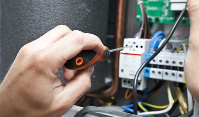 Electrician working on electrical panel wiring