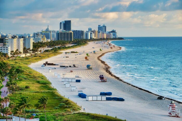 Miami Beach coastline at sunrise with cityscape.