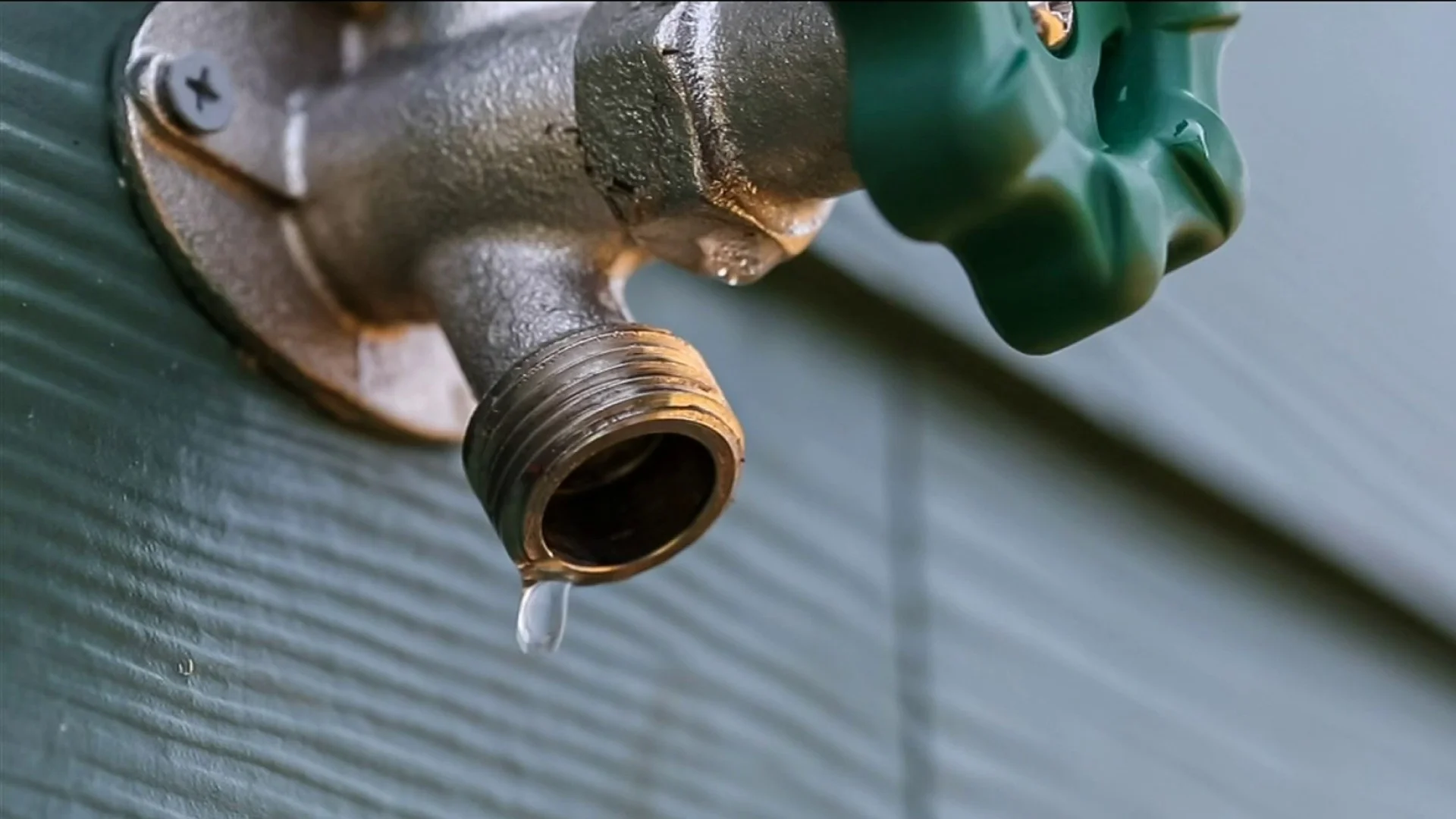 Outdoor metal faucet dripping water