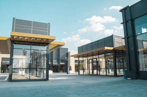 Modern glass-front commercial buildings under blue sky