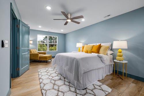 Modern bedroom with blue walls and yellow accents