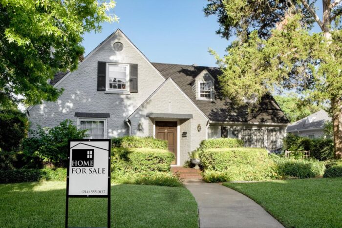 Suburban house with home for sale sign