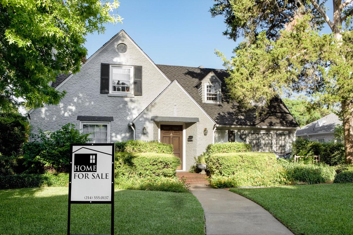 Suburban house with home for sale sign