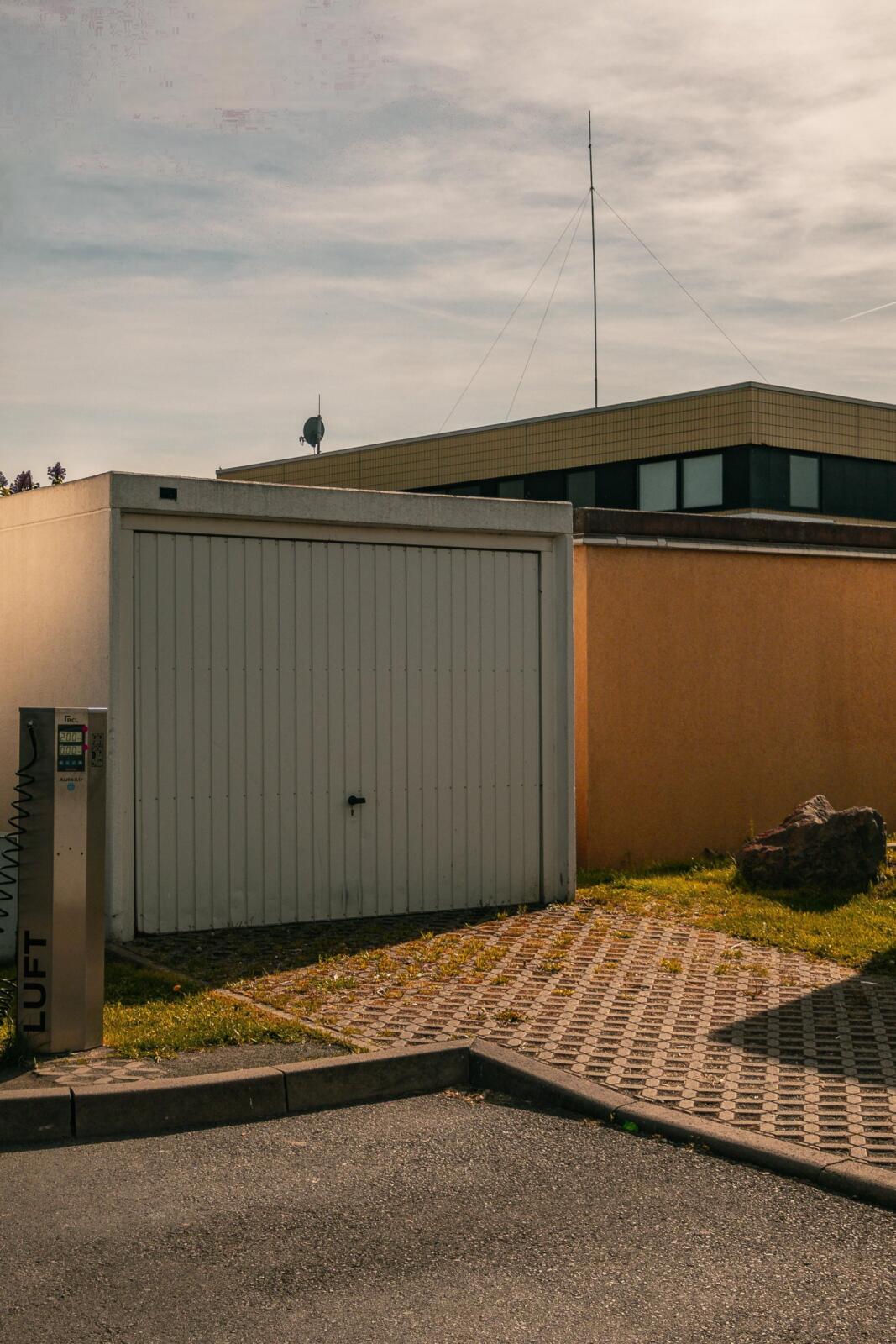 Garage door beside lift station under cloudy sky