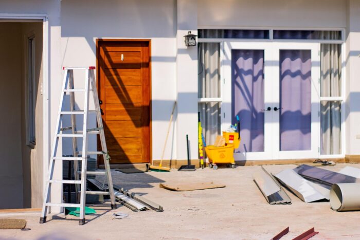 House entrance under renovation with ladder and construction materials