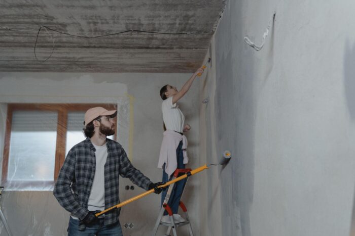 Homeowners painting interior walls during a home renovation project.
