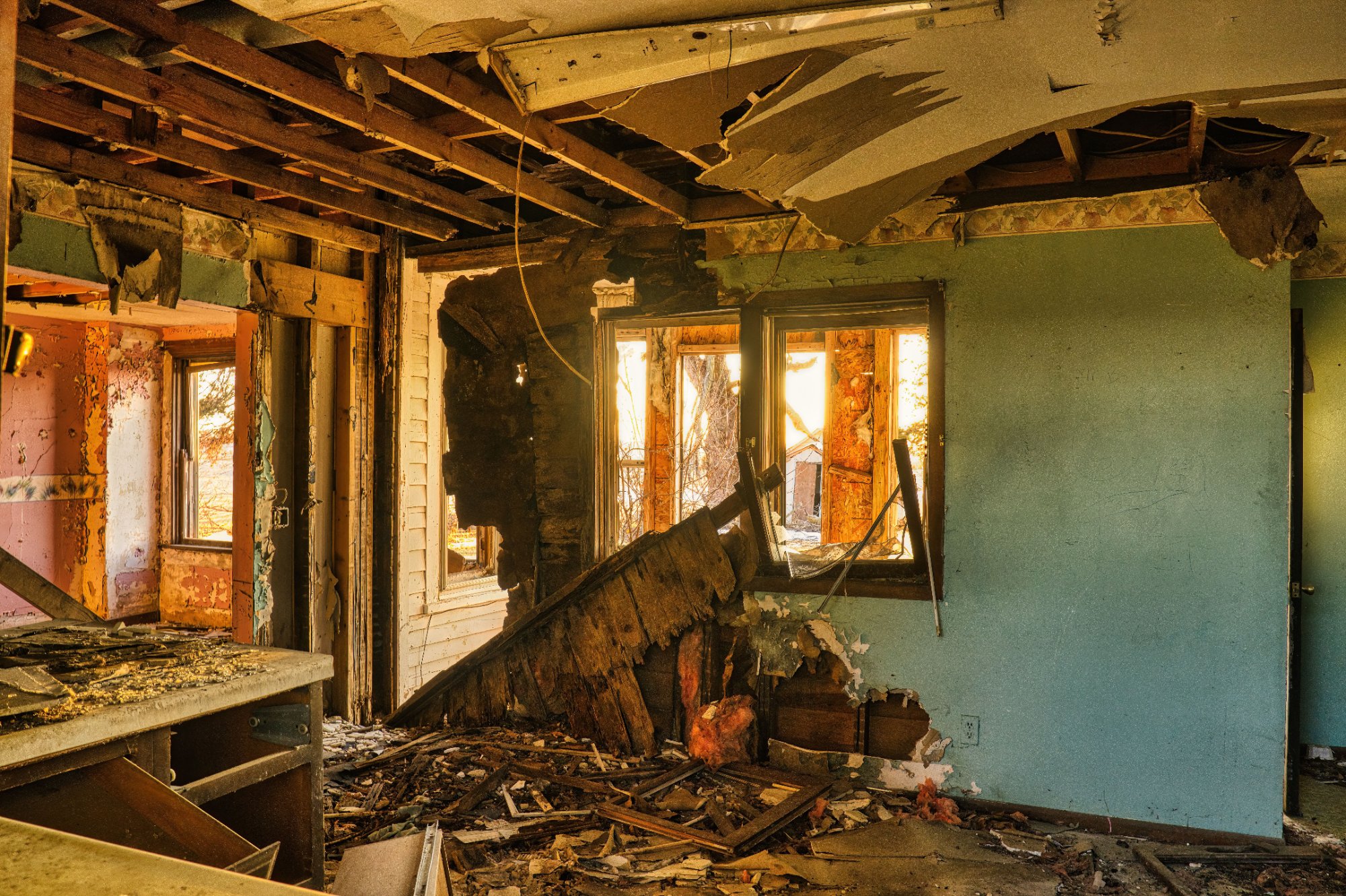 Fire-damaged abandoned room with collapsed ceiling and debris